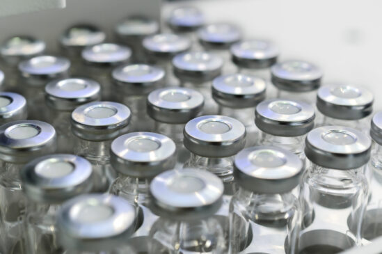 Glass vials for liquid samples. Laboratory equipment for dispensing fluid samples. Shallow depth of field.